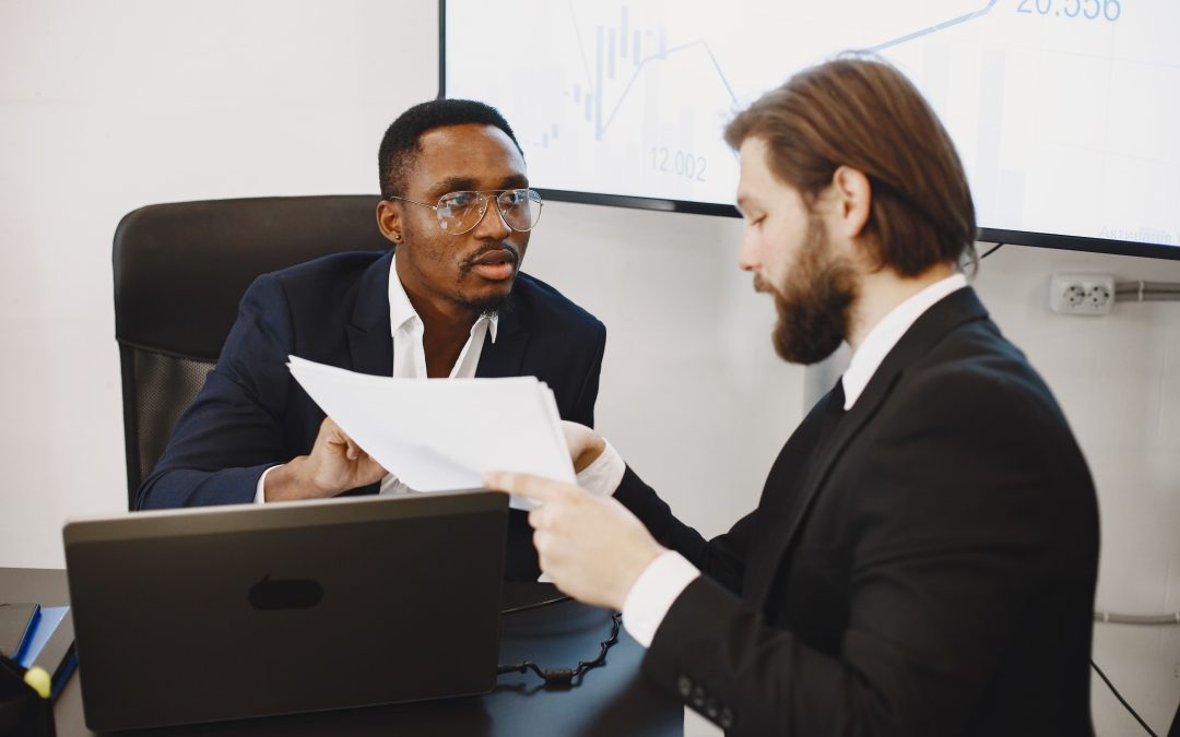 Two financial professionals discussing strategies for Texas wealth management and protecting family assets in a modern office.